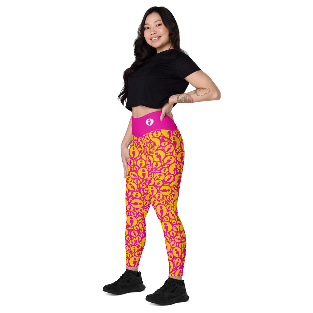 A woman modeling high-waisted athletic leggings with a vibrant pink Avatar pattern, paired with a black crop top and black sneakers, set against a plain white background.